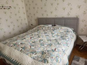 a bed with a quilt on it in a bedroom at Harz-Wohnung Natur pur in Benneckenstein