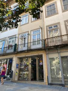 una mujer caminando por una calle frente a un edificio en Casa Augusta 3, en Braga