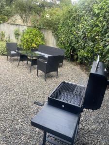 a barbecue grill and tables and chairs in a backyard at Grade 2 Cottage 1 bedroom, Ludlow centre in Ludlow