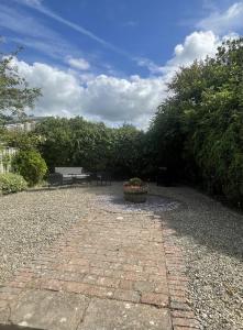 a stone walkway with a bench in a garden at Grade 2 Cottage 1 bedroom, Ludlow centre in Ludlow