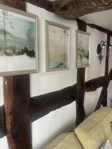 a room with three paintings on a wall with a couch at Grade 2 Cottage 1 bedroom, Ludlow centre in Ludlow