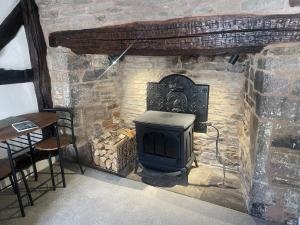 a stone fireplace with a stove in a room at Grade 2 Cottage 1 bedroom, Ludlow centre in Ludlow