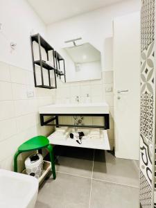 biała łazienka z umywalką i zielonym stołkiem w obiekcie Smart Silver Apartment Central w Bergamo