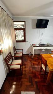 a living room with two chairs and a table and a television at Temporarios en Avellaneda Centro in Avellaneda