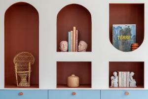 a shelf with books and statues and a mirror at New Flat Terracotta Style - Greater Paris district in Malakoff