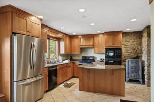 a kitchen with wooden cabinets and a stainless steel refrigerator at Ridgeline Views in Boone +31 photos