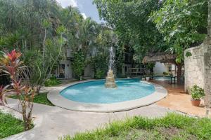 - une piscine avec une fontaine dans la cour dans l'établissement Mayan Art Hotel a unos pasos de la 5a Avenida, à Playa del Carmen