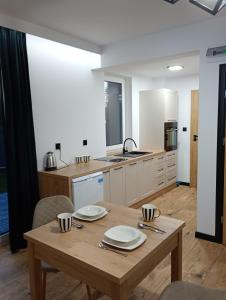 una cocina con una mesa de madera con platos. en Kaszmirowy zakątek, en Augustów