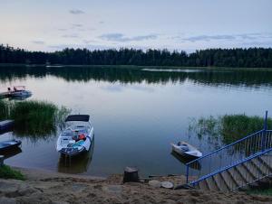dos barcos están atracados en un gran lago en Kaszmirowy zakątek, en Augustów