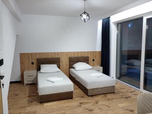 Un dormitorio con dos camas y una ventana. en Kaszmirowy zakątek, en Augustów