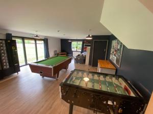a living room with a pool table and a room with at Stunning railway carriage with private hot tub in Hereford