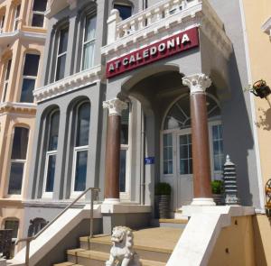 un edificio con un perro delante de él en At Caledonia, en Douglas