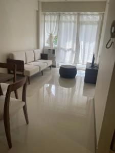 a living room with a white couch and a table at Ocean Garden Villas, Boracay New Coast in Boracay +6 photos