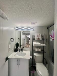 a bathroom with a white toilet and a sink at Adorable Private Suite in Seton SE, Calgary in Calgary