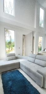 ein Wohnzimmer mit einem Sofa und einem blauen Teppich in der Unterkunft VILLA TOPOCORO HiDROSOGAMOSO in San Vicente de Chucurí