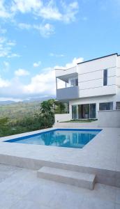 ein Haus mit einem Swimmingpool davor in der Unterkunft VILLA TOPOCORO HiDROSOGAMOSO in San Vicente de Chucurí