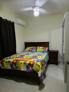 Un dormitorio con una cama con un edredón colorido. en Apartamentos swiss, en Sosúa 21 fotos más