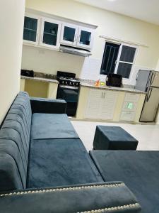 Una sala de estar con un sofá y una cocina. en Apartamentos swiss, en Sosúa
