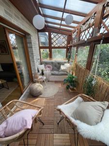 a living room with wicker chairs in a conservatory at Cozy Wilkipartment bis 4 Pers - Hund - Netflix - WLAN - Wintergarten - Coffeebar - Popcorn in Verl