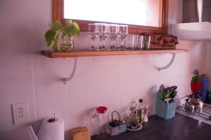 une cuisine avec un comptoir et des verres sur une étagère dans l'établissement Quiñehuen, à San Martín de los Andes 96 autres photos