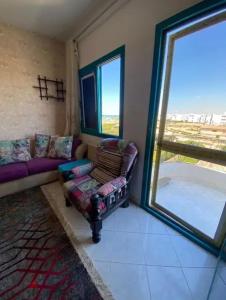 un salon avec une baignoire, un canapé et une fenêtre dans l'établissement شاليه للإيجار في راس سدر جولدن بيتش2, à Raʼs Matarma