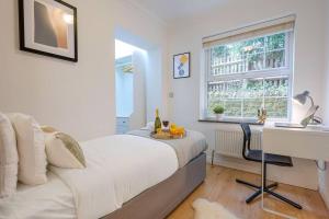 a bedroom with a bed and a desk and a window at Stylish Apartment - Central Location - Free Parking, Self-Check-In, Fast Wifi and Smart TV by Yoko Property in Northampton