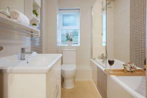a white bathroom with a toilet and a sink at Stylish Apartment - Central Location - Free Parking, Self-Check-In, Fast Wifi and Smart TV by Yoko Property in Northampton