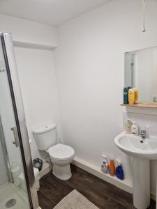 a white bathroom with a toilet and a sink at Legends Court, Wolverhampton in Wolverhampton