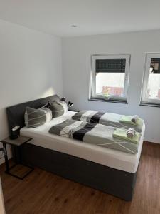 een groot bed in een slaapkamer met 2 ramen bij Ferienhaus Ma Bella in Forchheim