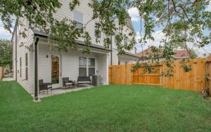 a house with a wooden fence and a yard at Urban luxe Getaway 4 mins to DT Newly Built Home in Houston