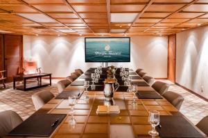 a large conference room with a long table and a screen at Pacific Terrace Hotel in San Diego
