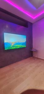 a room with a large screen with purple lights at Dar sirin in Essaouira