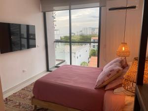 a bedroom with a bed and a large window at Excepcional-ApartaSuite-vista al Mar-2 camas in Santa Marta +37 photos