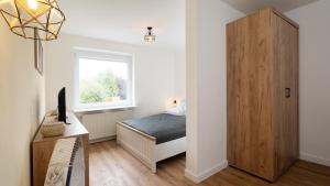 a small bedroom with a bed and a wooden cabinet at Captains Quarters 5 in Dahme in Dahme