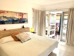 a bedroom with a bed and a painting on the wall at Casa de las Olas Surf & Beach Club in Acapulco