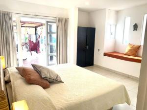 a bedroom with a large bed with pillows on it at Casa de las Olas Surf & Beach Club in Acapulco