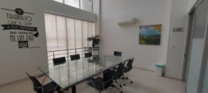 a conference room with a glass table and chairs at Hotel Berdez in Neiva
