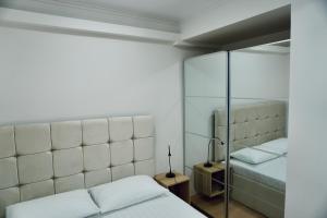 Un dormitorio con dos camas y un espejo. en Central Charm Apartment, en Tîrgu Neamţ