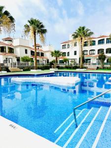 una grande piscina con palme sullo sfondo di Perla de Tenerife a Puertito de Güímar