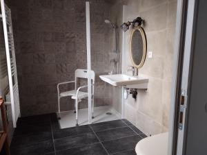 a bathroom with a sink and a chair in it at Gîte accessible à la campagne in Orliac-de-Bar