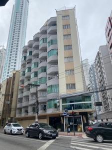 a large building with cars parked in a city at Balneário Camboriú lindo apto proximo Mar in Balneário Camboriú