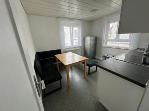 a small kitchen with a table and a refrigerator at Comfort Apartments Heilbronn in Heilbronn