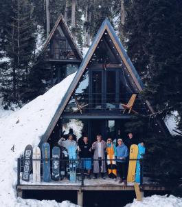 un gruppo di persone che si trovano di fronte a una cabina con snowboard di Bakhmaro A-frame a Chʼkhakoura