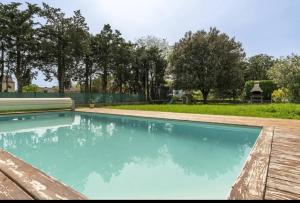 une piscine dans une cour avec des arbres en arrière-plan dans l'établissement Villa spacieuse avec piscine à Saint-Laurent-la-Vernède, à Saint-Laurent-la-Vernède 13 autres photos