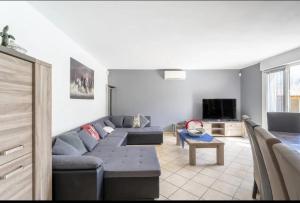 un salon avec un canapé et une télévision dans l'établissement Villa spacieuse avec piscine à Saint-Laurent-la-Vernède, à Saint-Laurent-la-Vernède