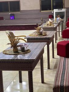 a row of tables in a room with red chairs at Royal Dunes Camp in Wadi Rum