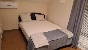 a small bedroom with a bed in a room at Vila Vesna in Gornji Karin