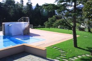 uma piscina com uma árvore num quintal em B&B Podere Montese em Villafranca in Lunigiana