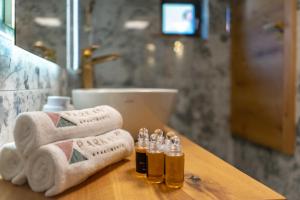 a bathroom counter with towels and essential oils on it at Parkan 127 Apartments in Český Krumlov +30 photos