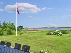 a flag on a pole in a field with chairs at 6 person holiday home in Jægerspris-By Traum in Jægerspris +40 photos